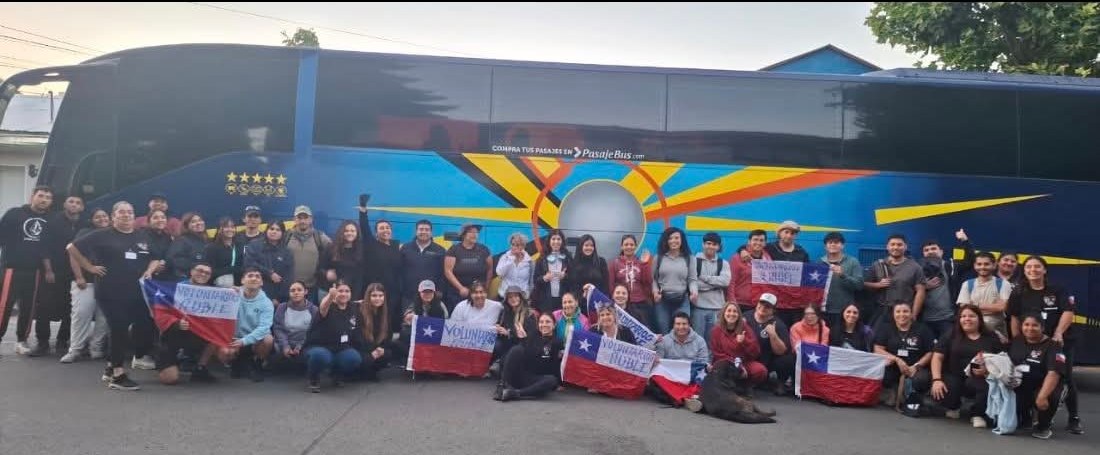 Grupo de voluntarios junto a bus Reyes